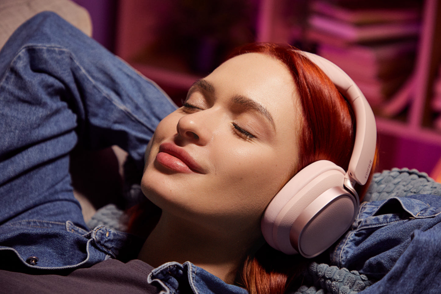 Mujer relajada escuchando música con los auriculares Edifier ES850NB color rosa