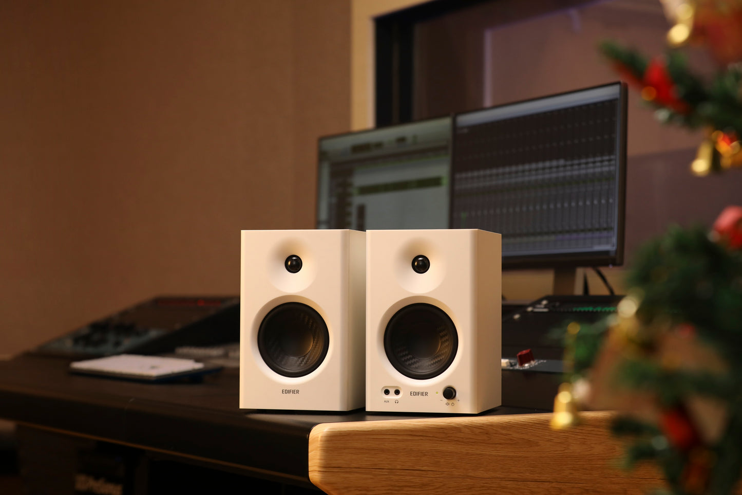 Par de monitores Edifier MR4 blancos en estudio decorado con árbol de Navidad.