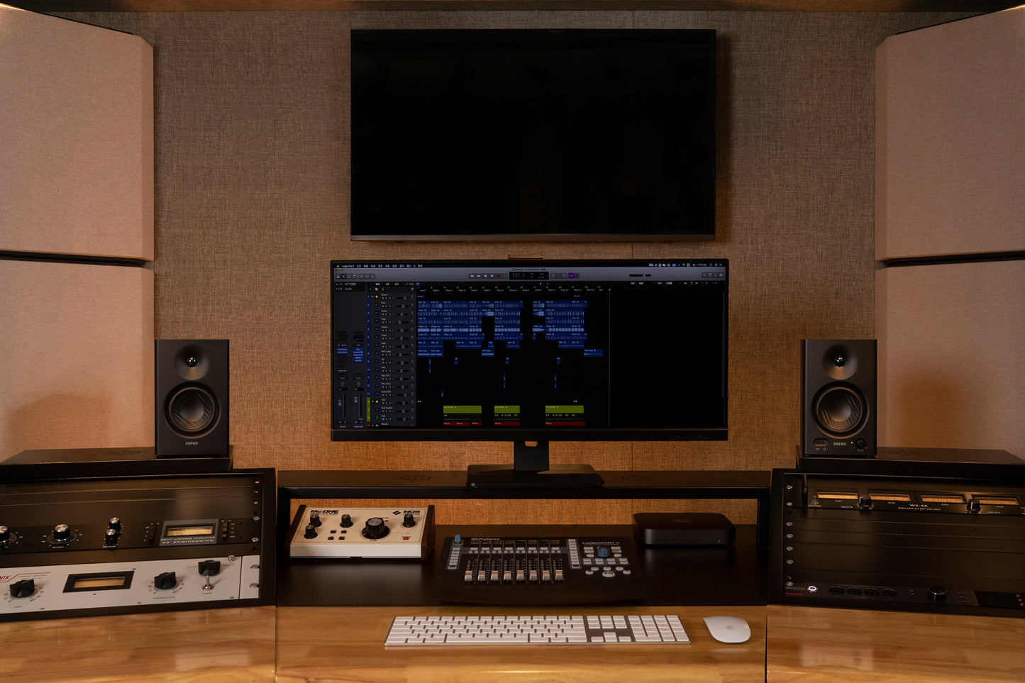 Monitores de estudio Edifier MR4 en color negro, posicionados junto a una pantalla de edición en un setup profesional.