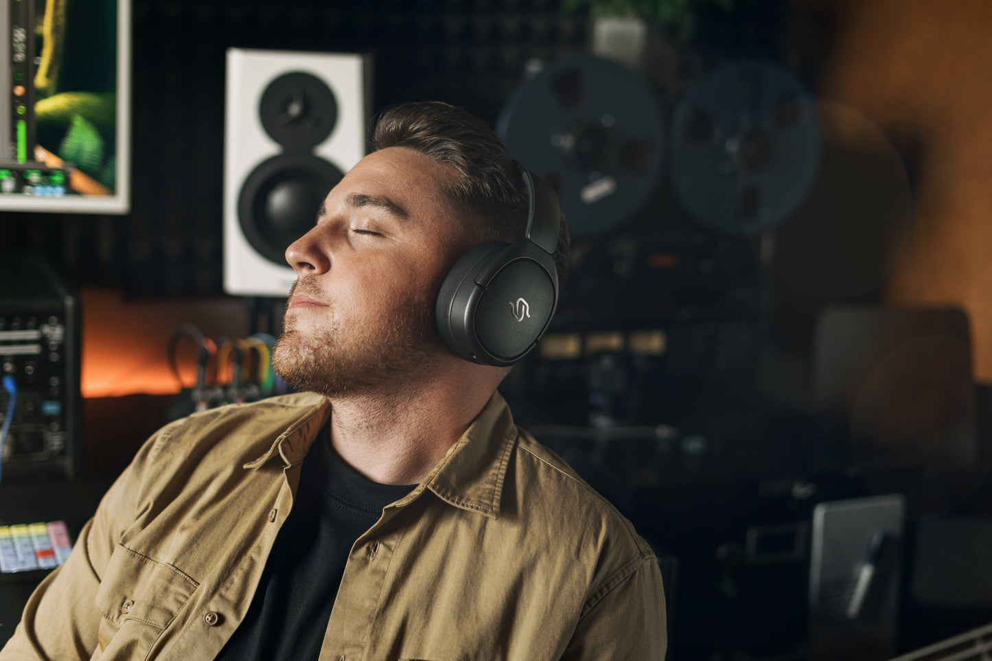 Hombre disfrutando la música con Edifier STAX SPIRIT S5 en un estudio de grabación