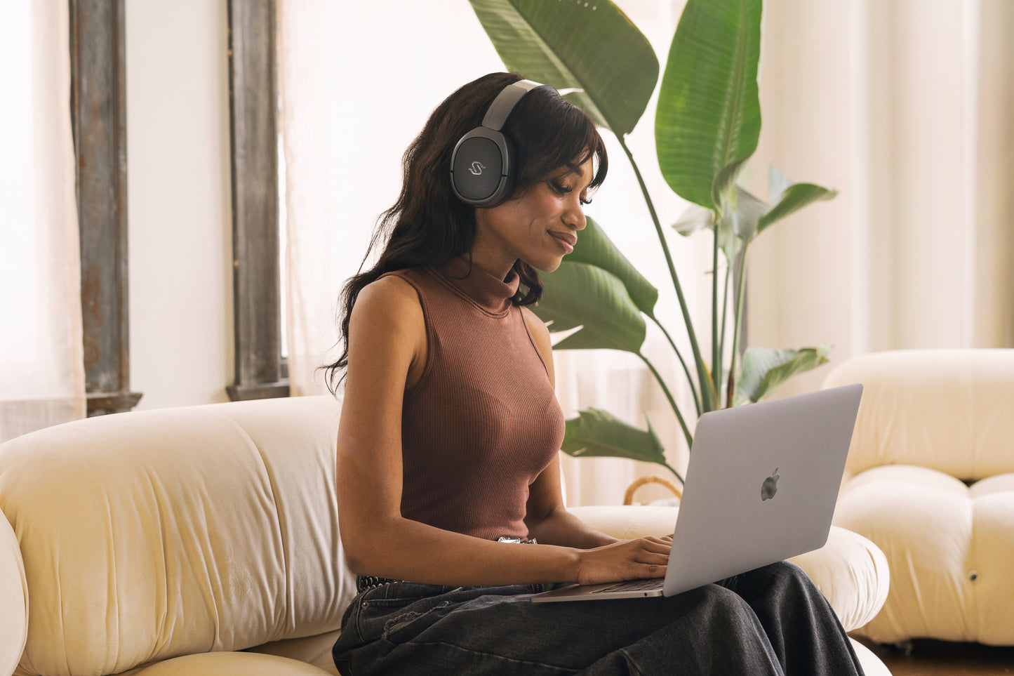 Mujer trabajando en laptop con auriculares Edifier STAX SPIRIT S5