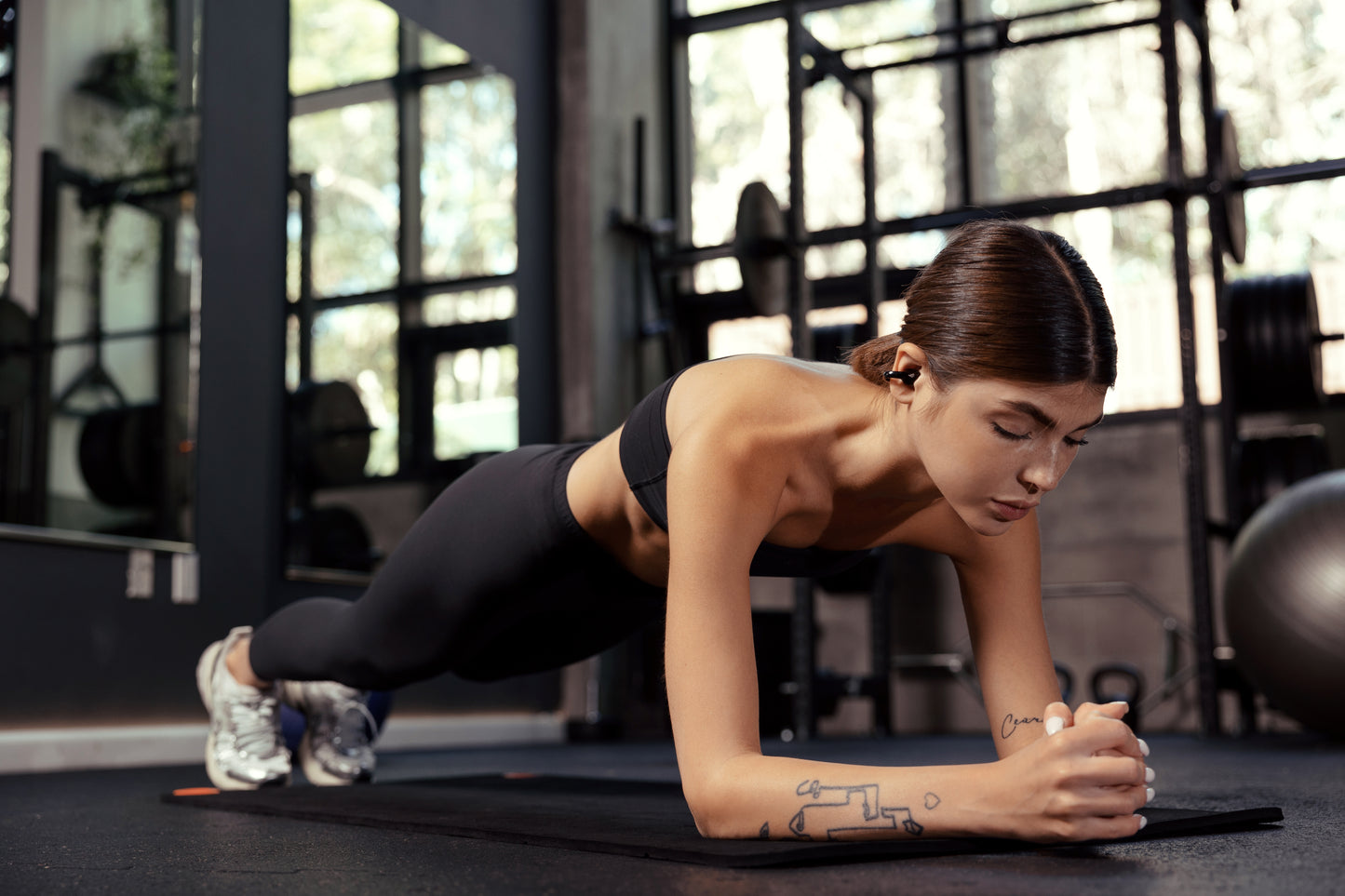 Mujer entrenando en el gimnasio con auriculares Edifier Comfo C puestos, diseñados para deporte