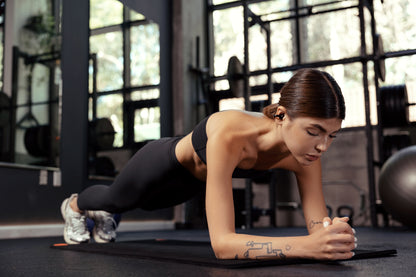 Mujer entrenando en el gimnasio con auriculares Edifier Comfo C puestos, diseñados para deporte