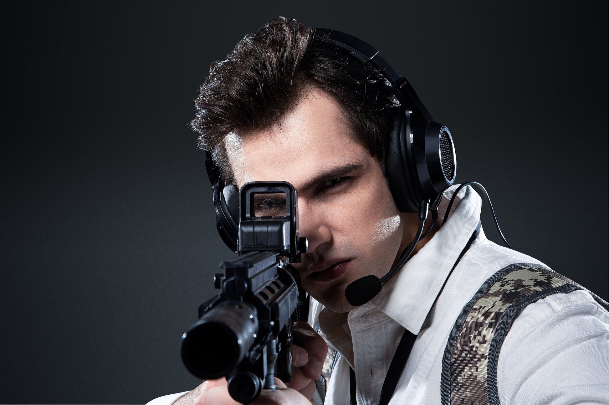 Gamer usando auriculares Edifier G2 II negros mientras apunta con rifle en escena