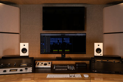 Monitores de estudio Edifier MR4 en color blanco en un estudio con pantalla de mezcla y tratamiento acústico.