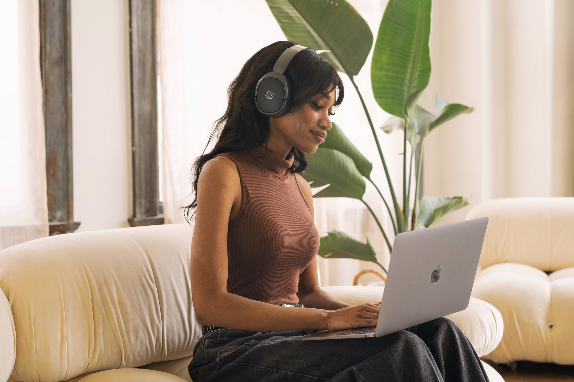 Mujer trabajando en laptop con auriculares Edifier STAX SPIRIT S5
